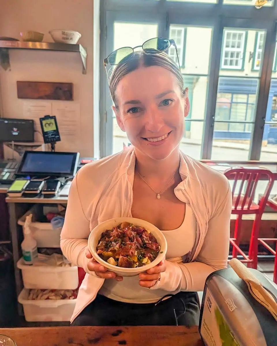 Bailey holding poutine at Le Chic Shack in Old Quebec City