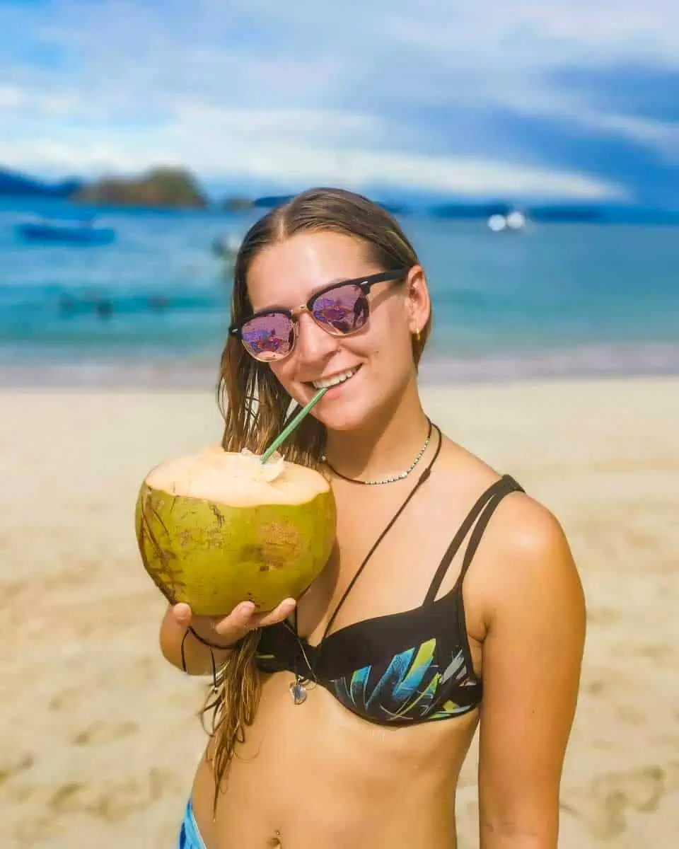 Bailey sipping a coconut on a kayak tour in Nassau