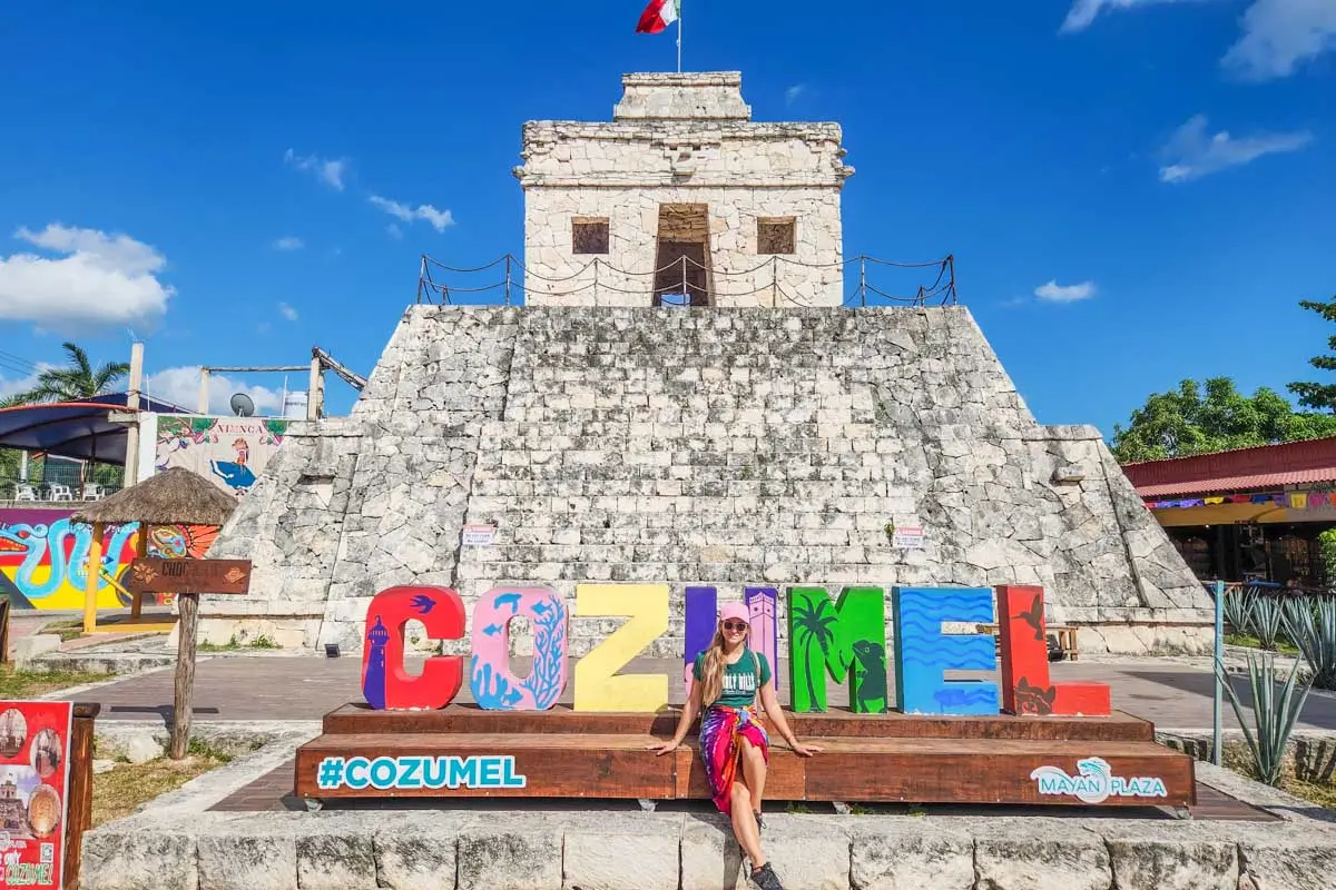 Bailey sitting at Cozumel sign in Cozumel, Mexico