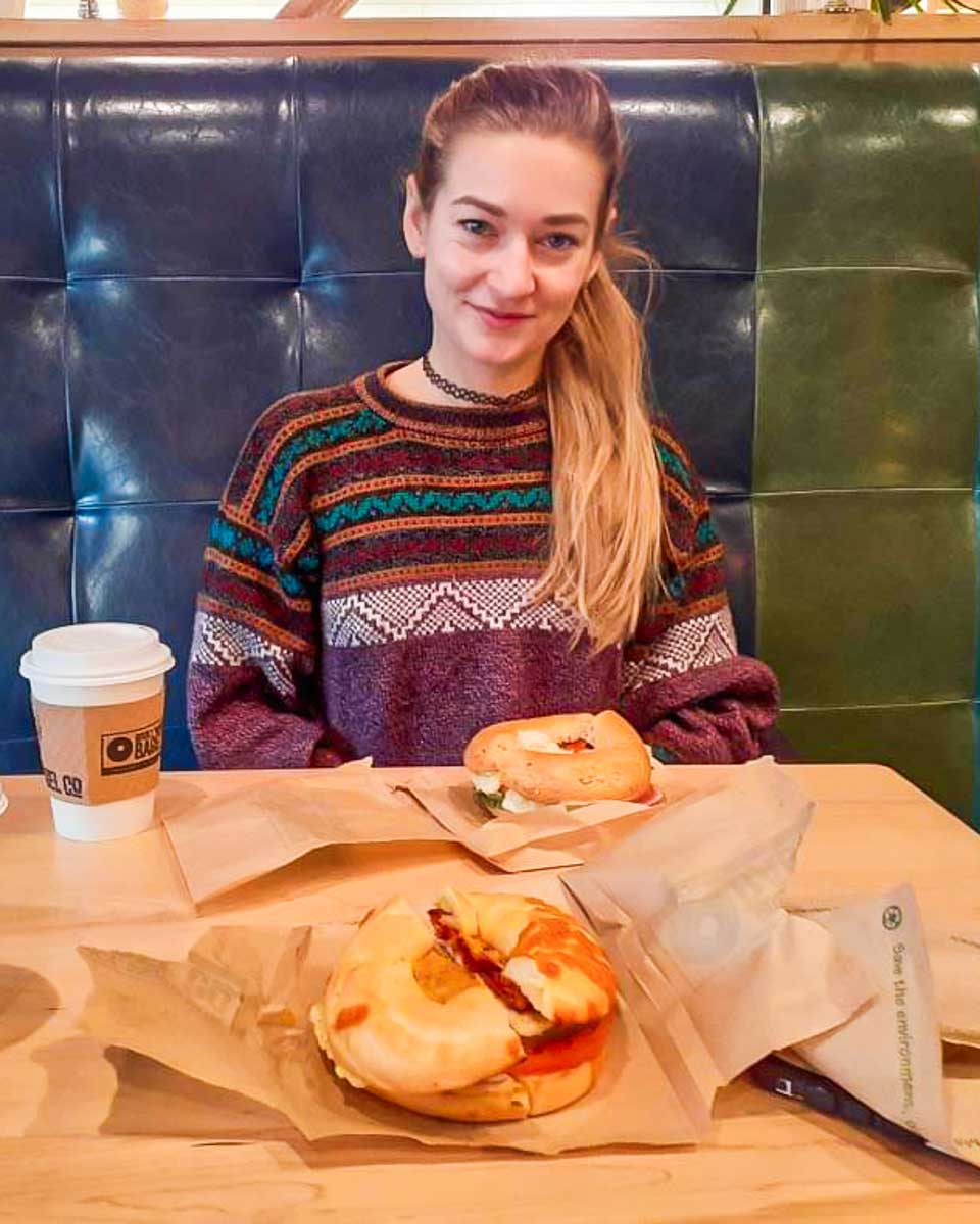 Bailey smiles with her bagel from Rocky Mountain Bagel company in Canmore