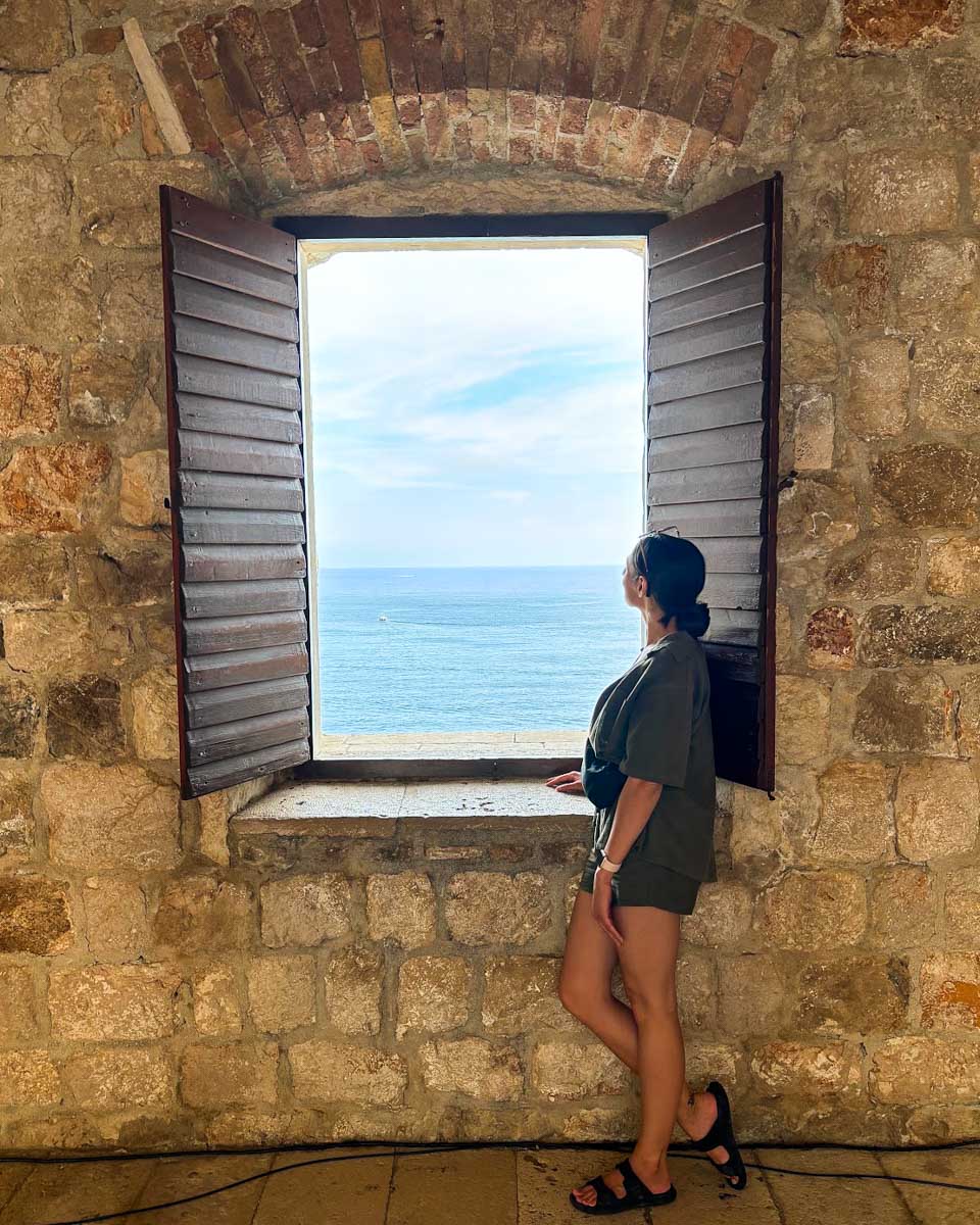 Brittni looks out the window at Fort Lovrjenac in Dubrovnik, Croatia