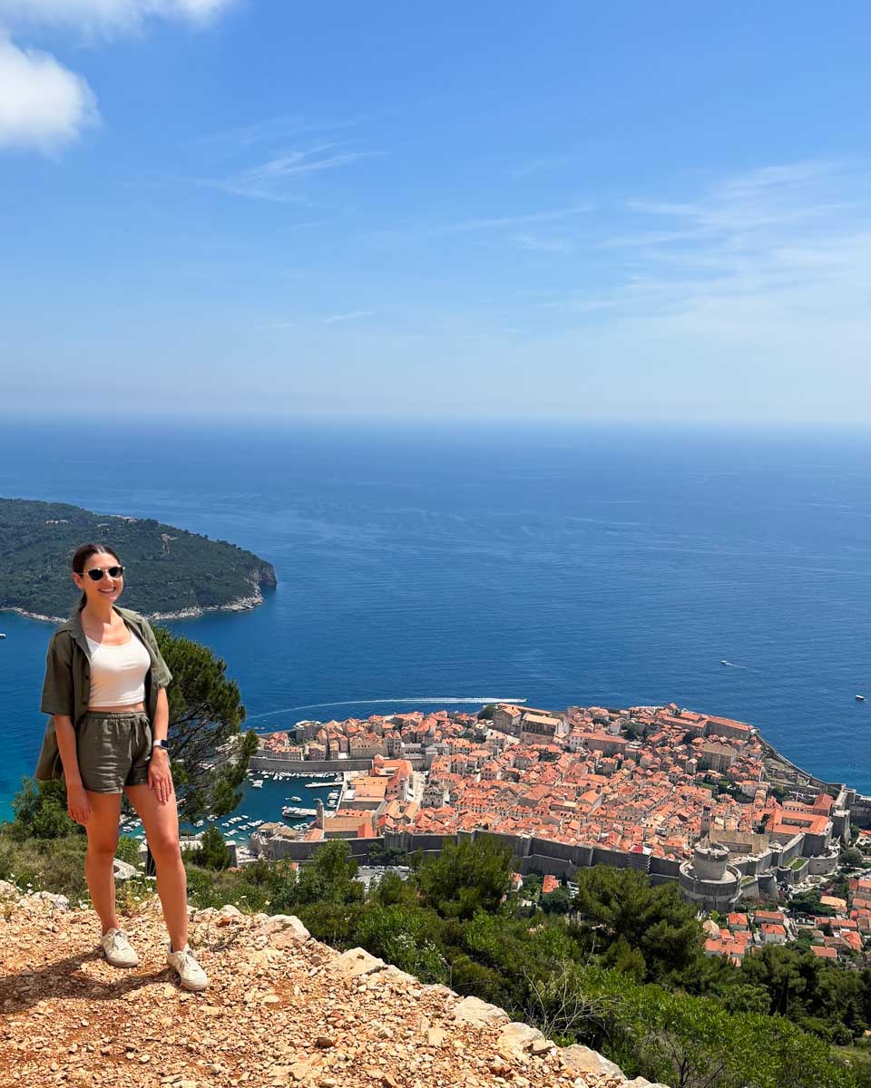 Brittni poses for a photo with Old Town in the background while walking down from Mt Srd in Dubrovnik, Croatia