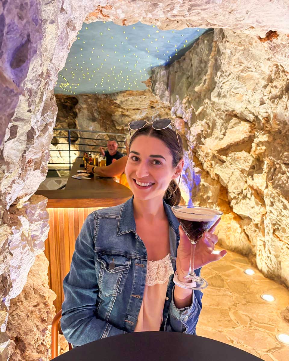 Brittni smiles with a cocktail at Cave Bar More in Dubrovnik