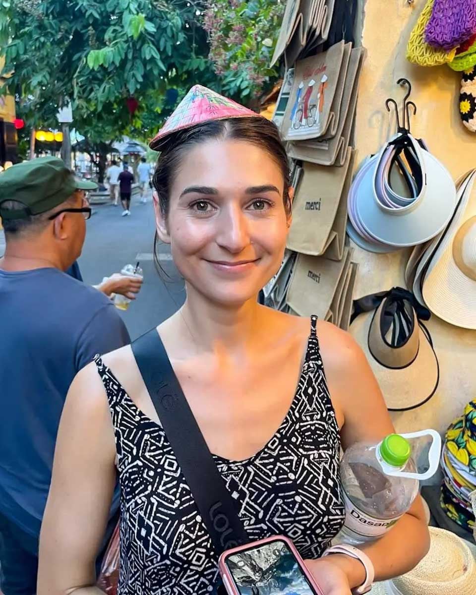 Brittni-wearing-traditional-Vietnamese-hat-at-a-shop-in-Ben-Thanh-Vietnam 