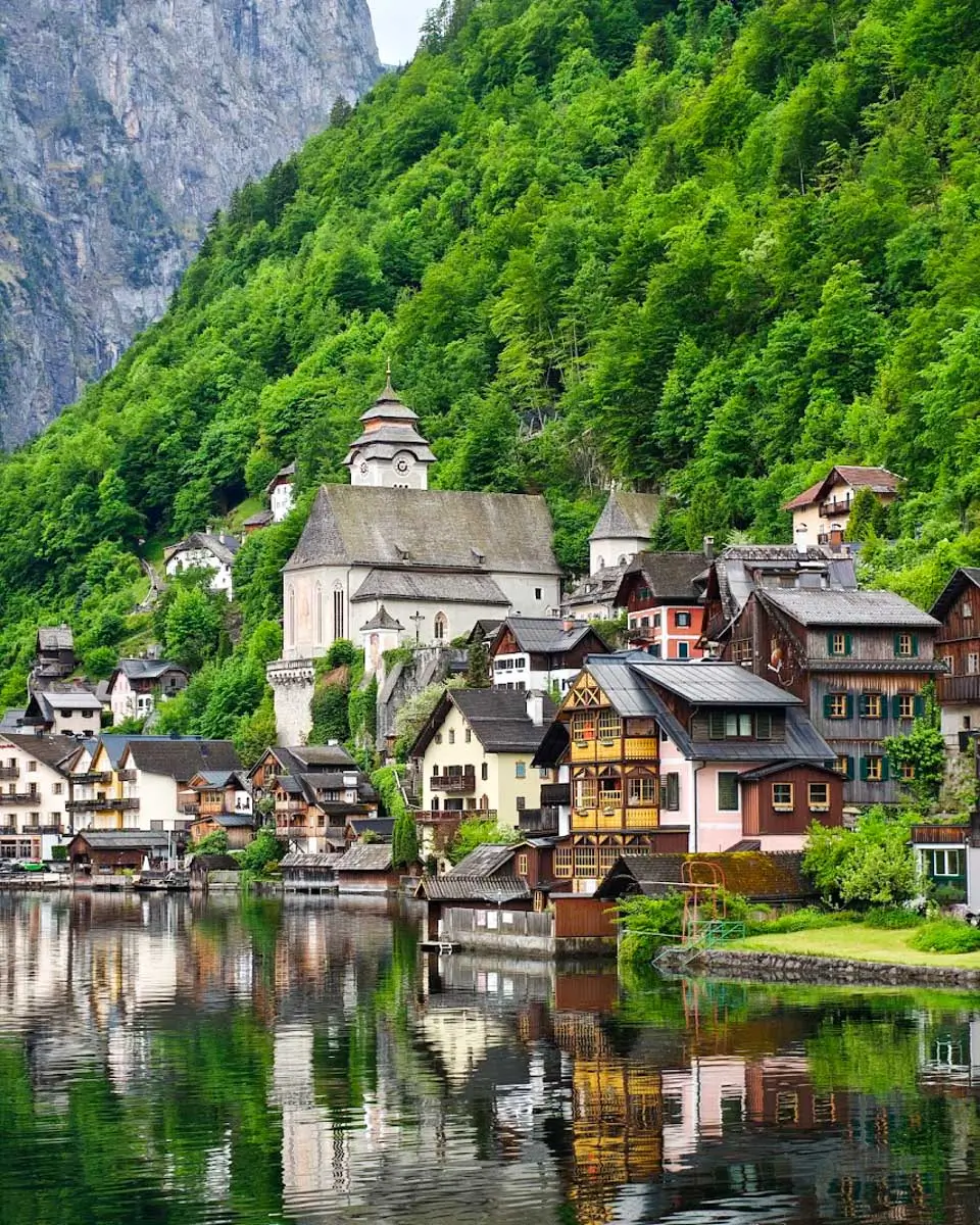 Colorful lakeside houses and church surrounded by mountains in Hallstatt, Austria