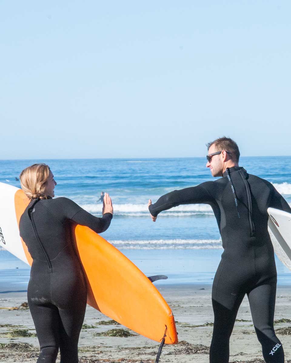 Daniel and Bailey doing high five before going for a surf in Newport Beach
