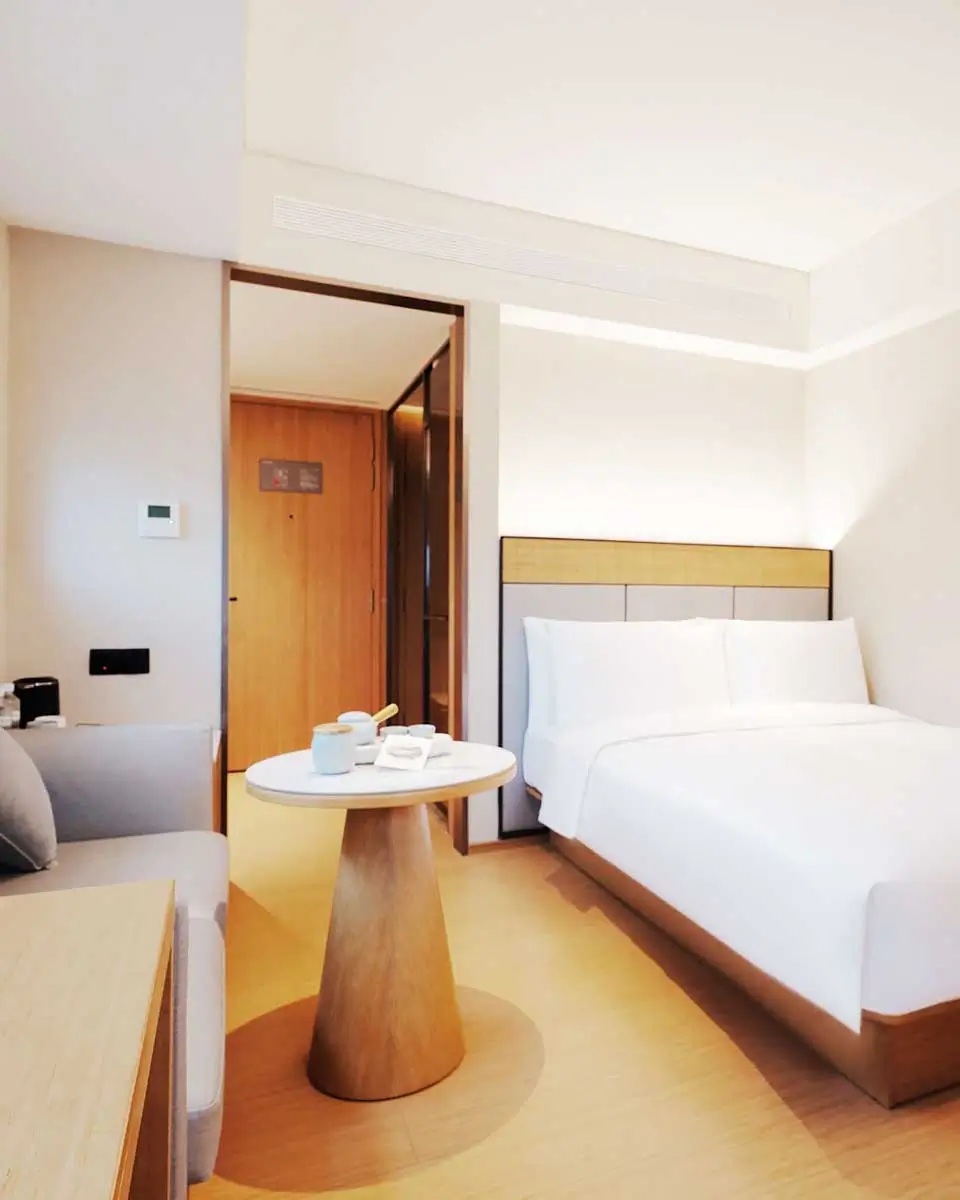 Bright guest room at JI Hotel Orchard Singapore with a comfortable bed, desk, and modern furnishings