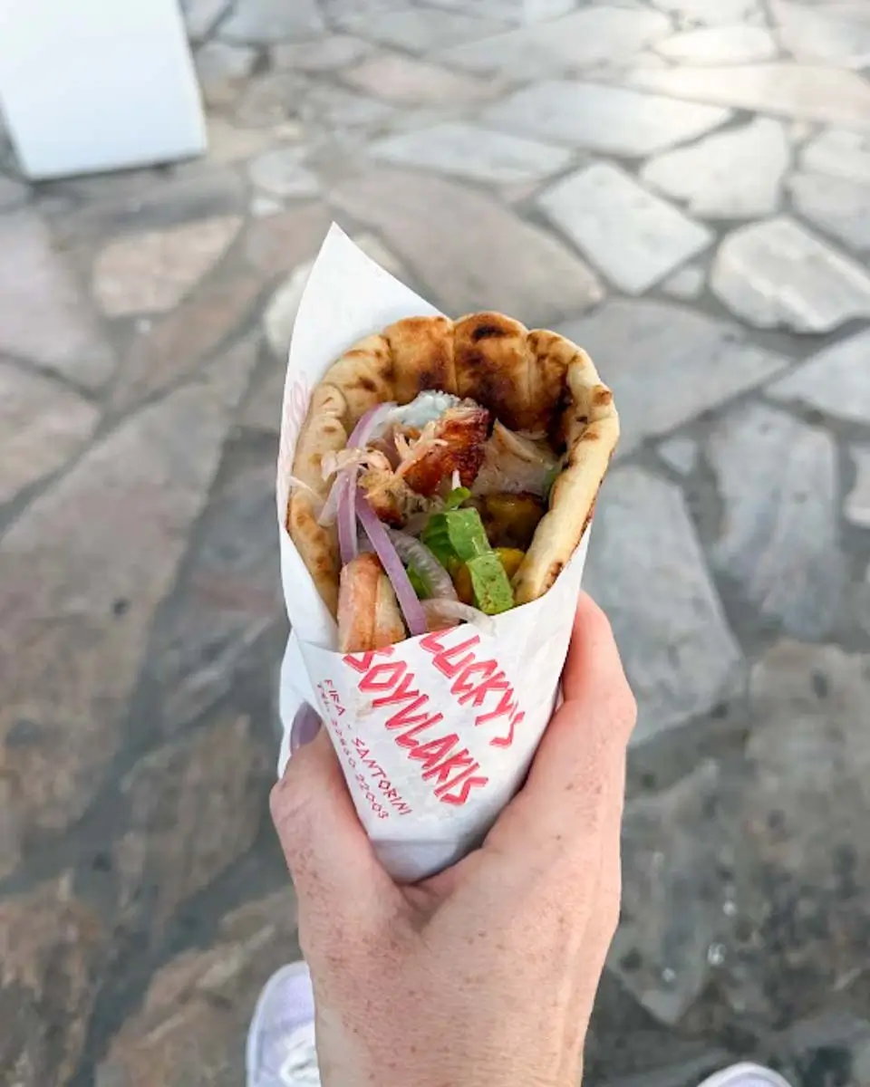 Hannah holding Lucky's Sovlaki Wrap in Fira, Greece