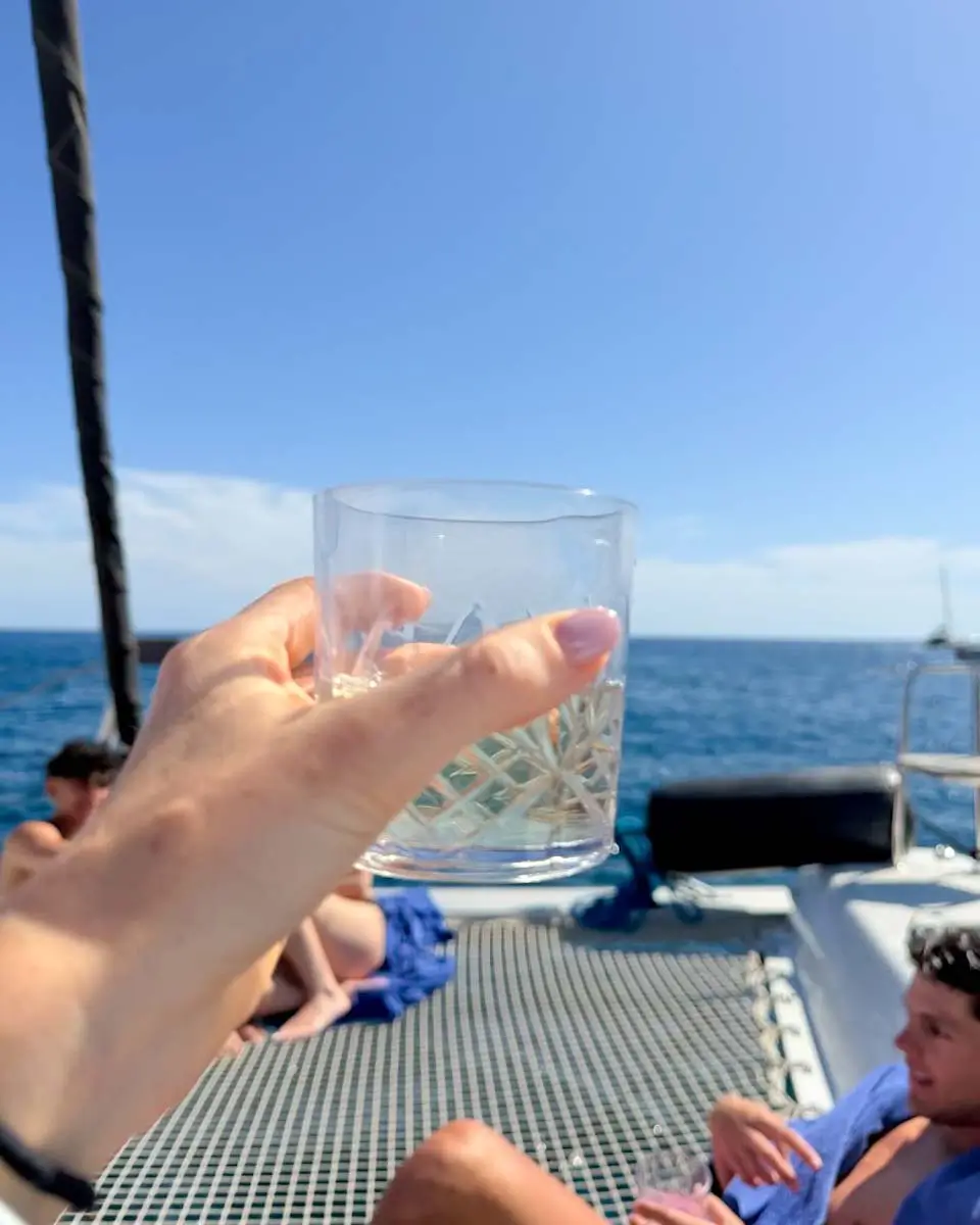 Hannah holding a drink on a catamaran cruise in Naxos, Greece