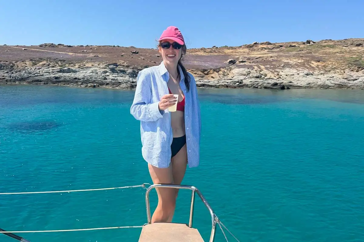 Hannah holding a drink on a catamaran cruise tour in Naxos, Greece