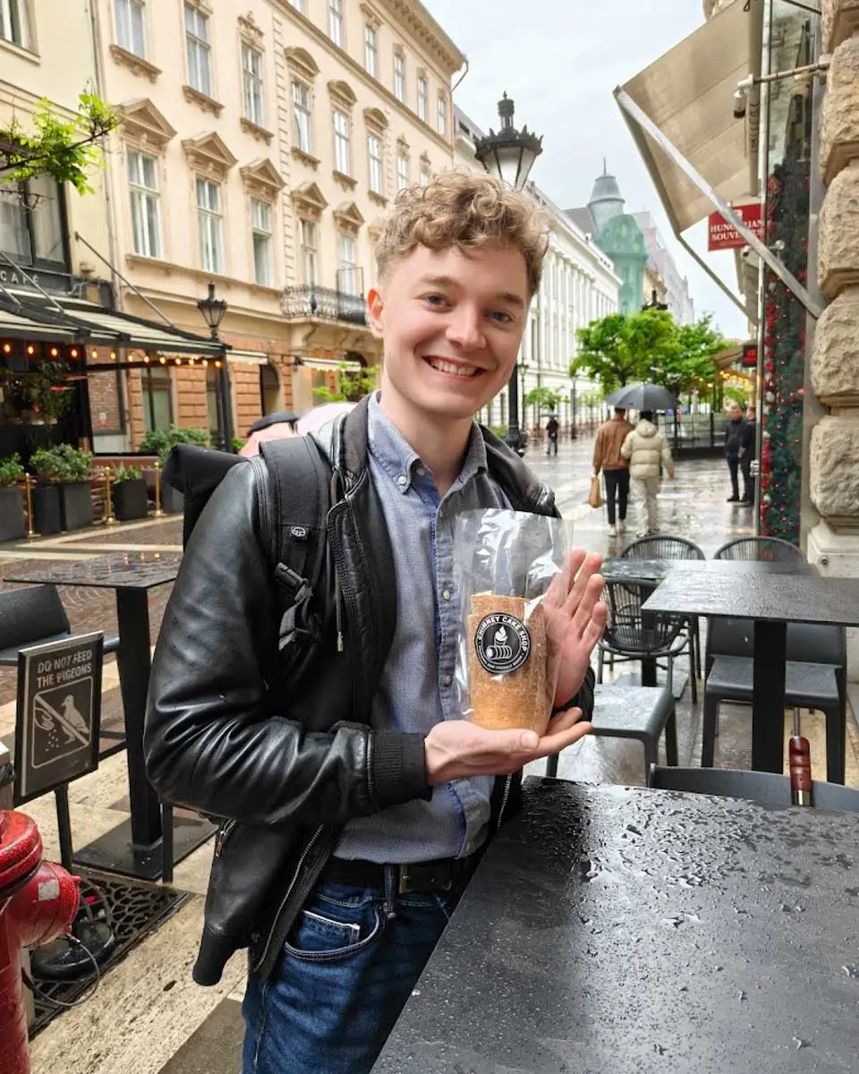 Luke holding a chimney cake while exploring Budapest on a food tour
