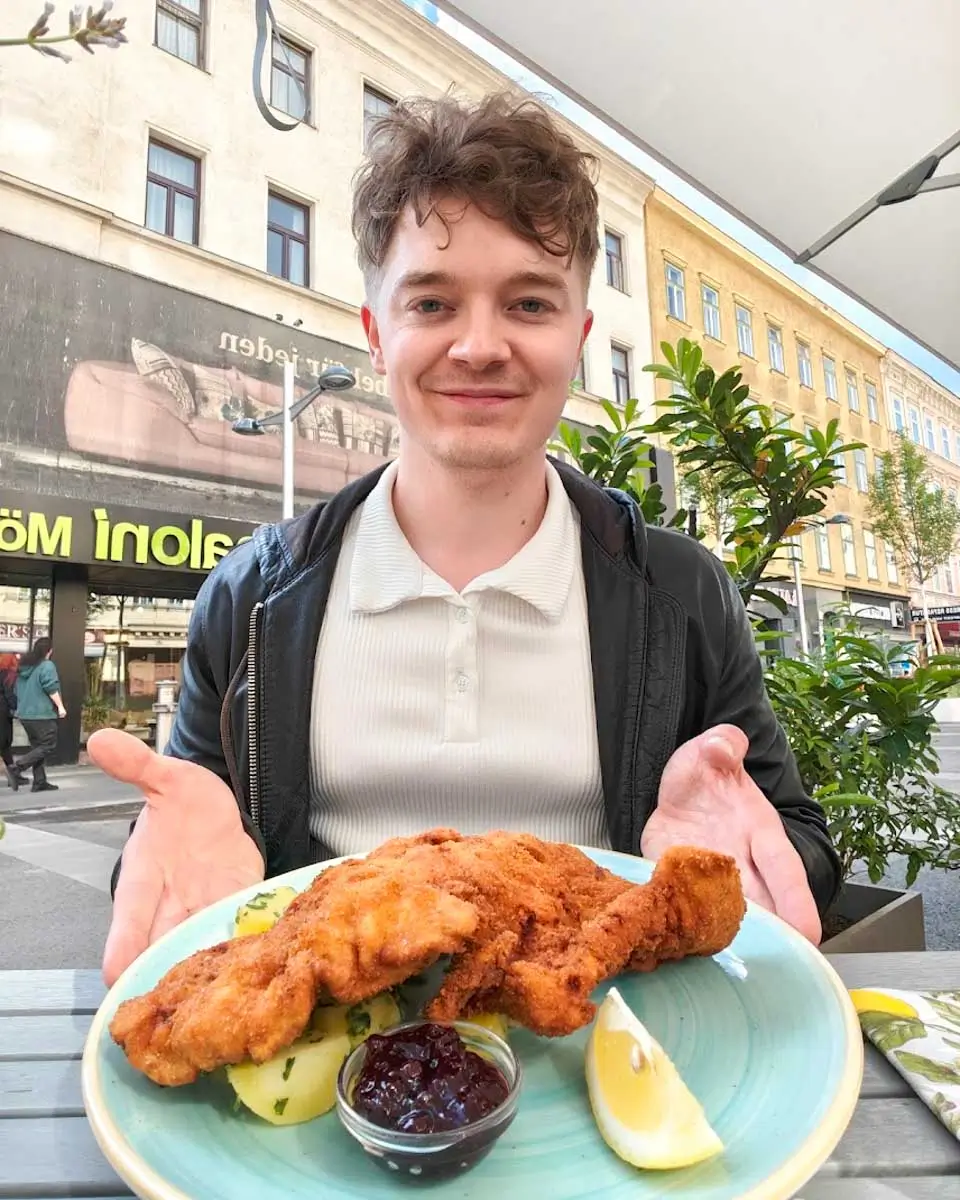 Luke holding a plate of traditional Wiener Schnitzel in Vienna
