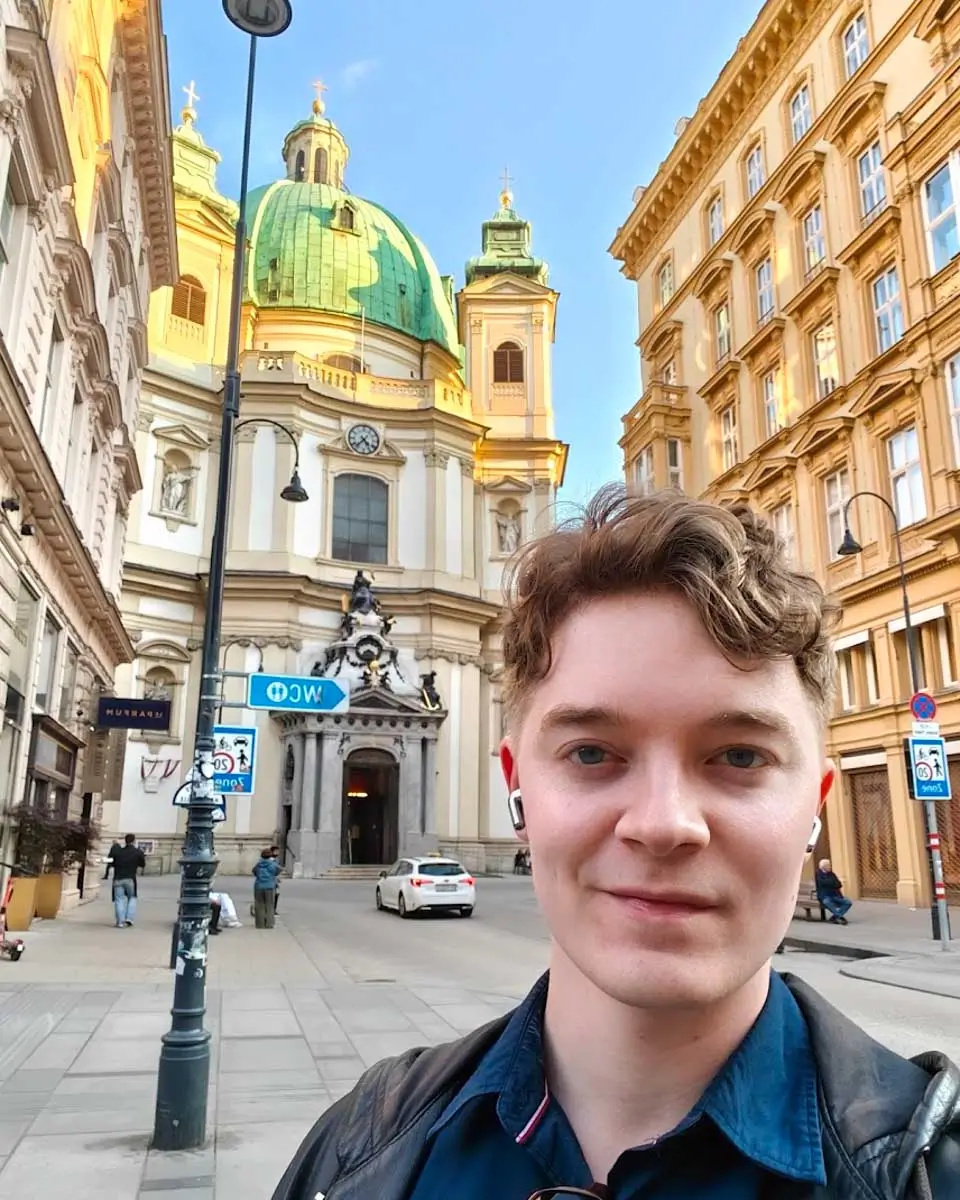 Luke taking selfie with St. Peter's Church in background in Vienna
