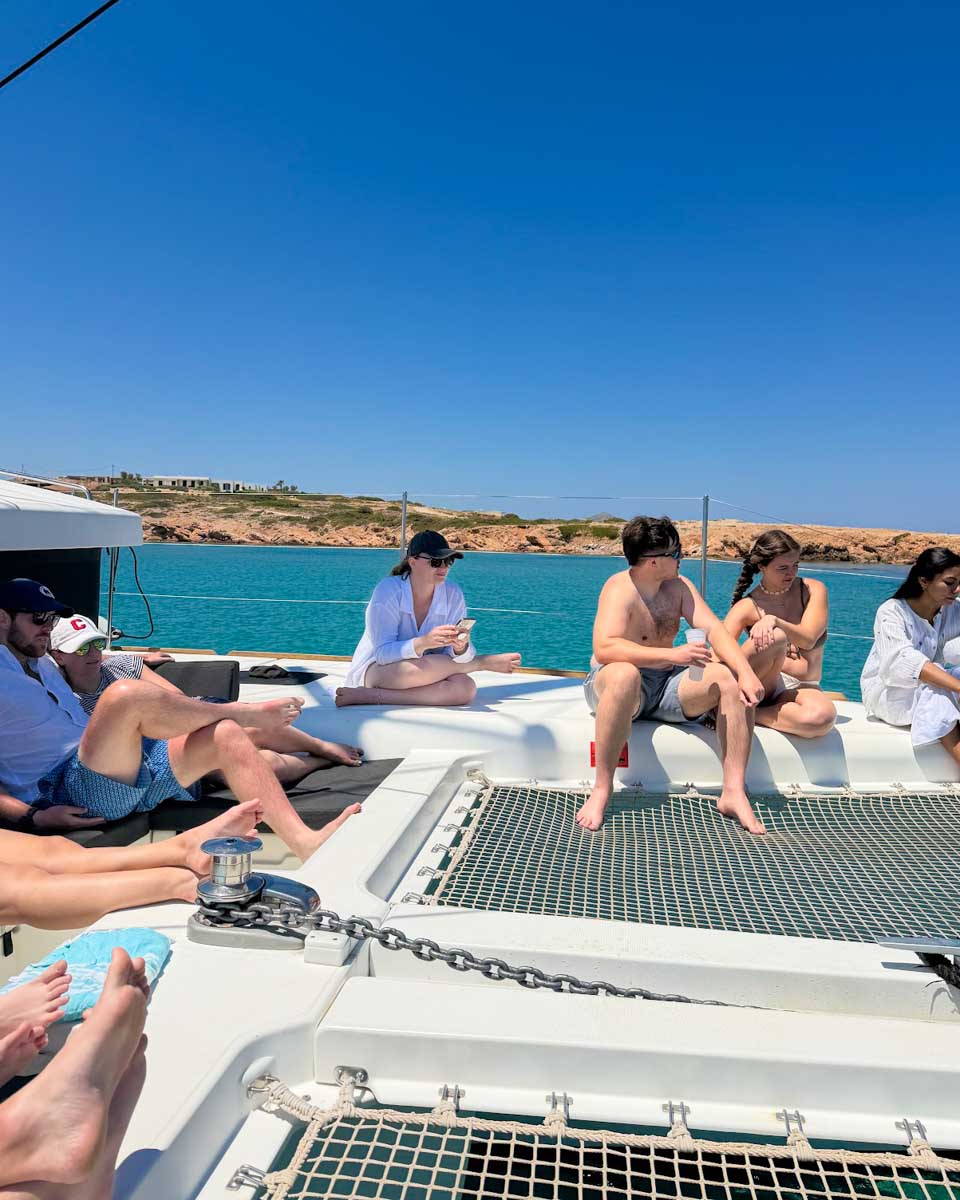 People lounge on a catamaran on a tour in Naxos, Greece