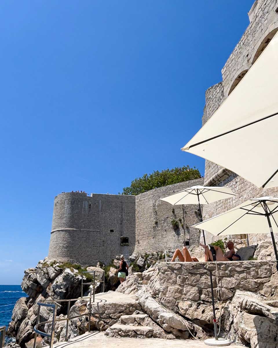 People lounge on the cliff at Buza Bar in Dubrovnik