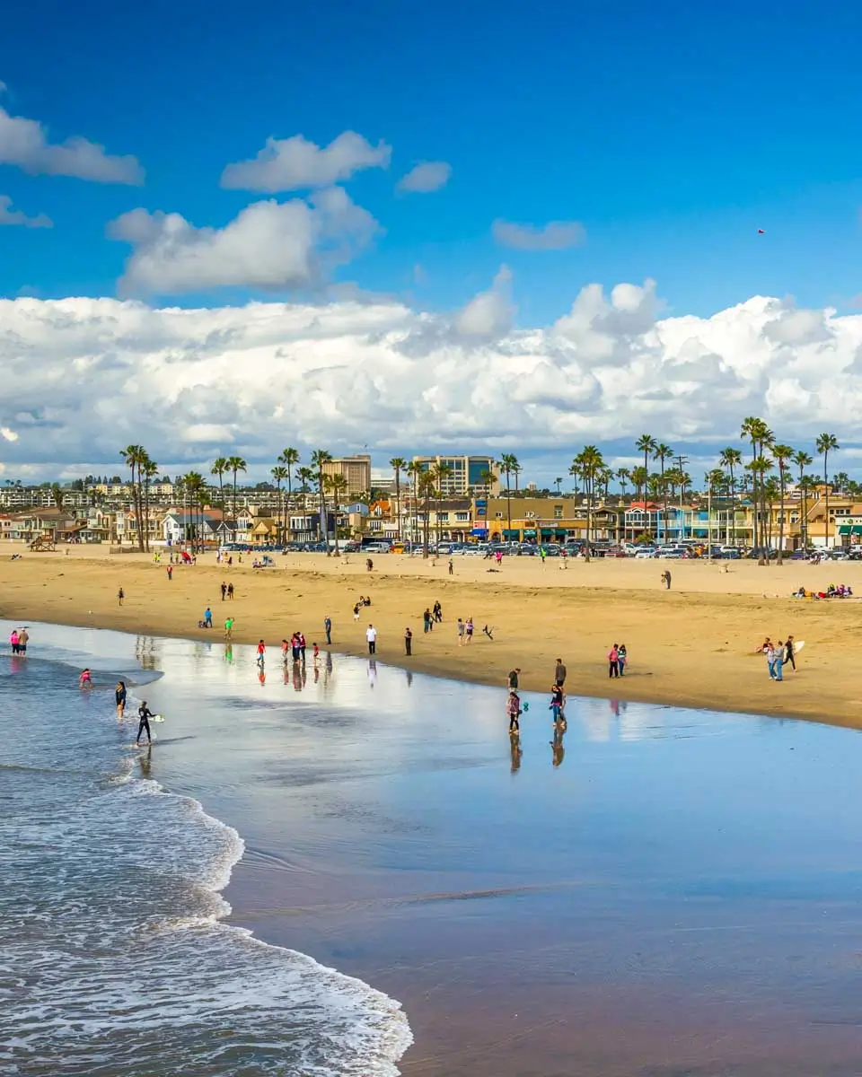 People walk on Newport Beach, California