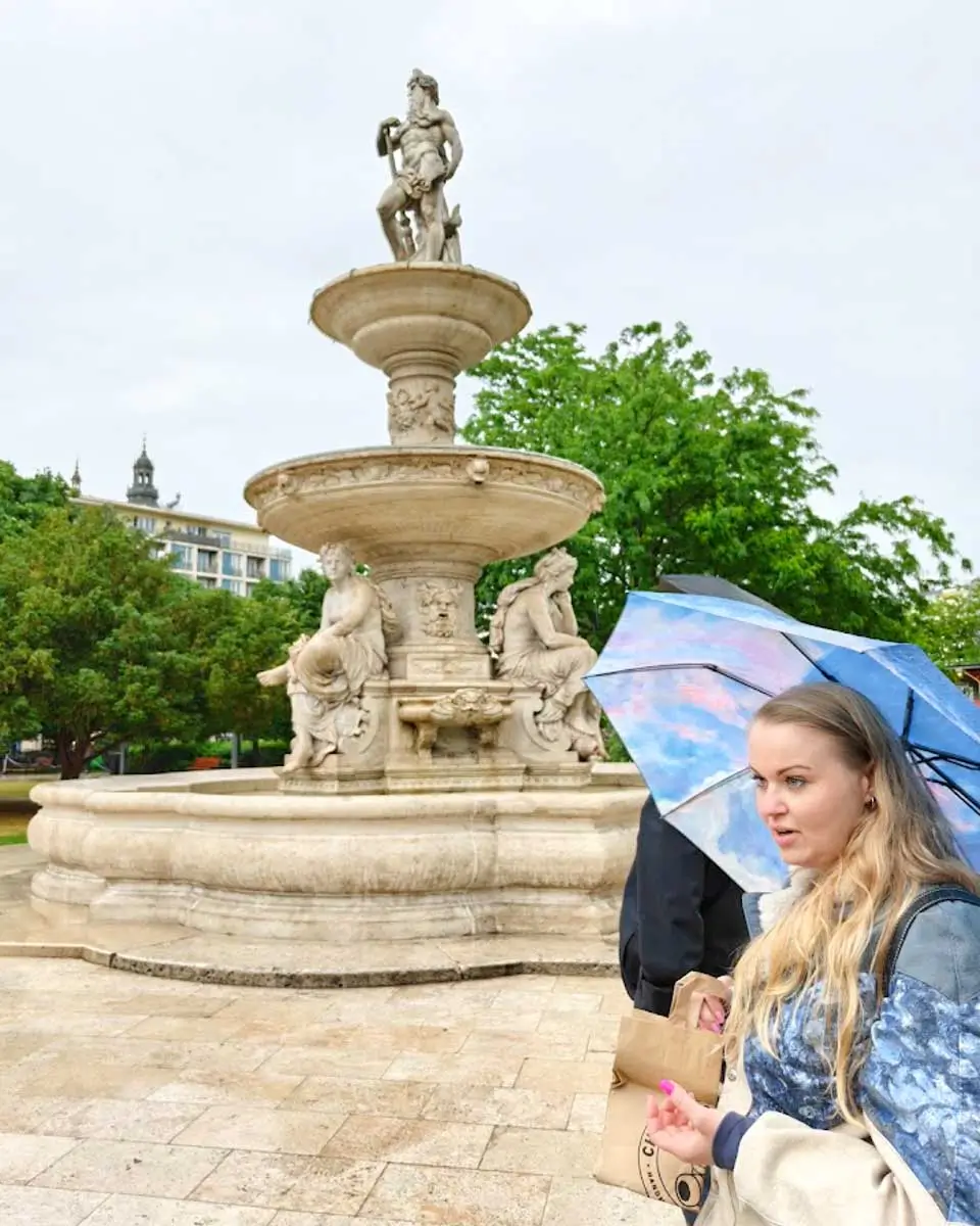 Food tour guide Kitty standing near a historic fountain in Budapest