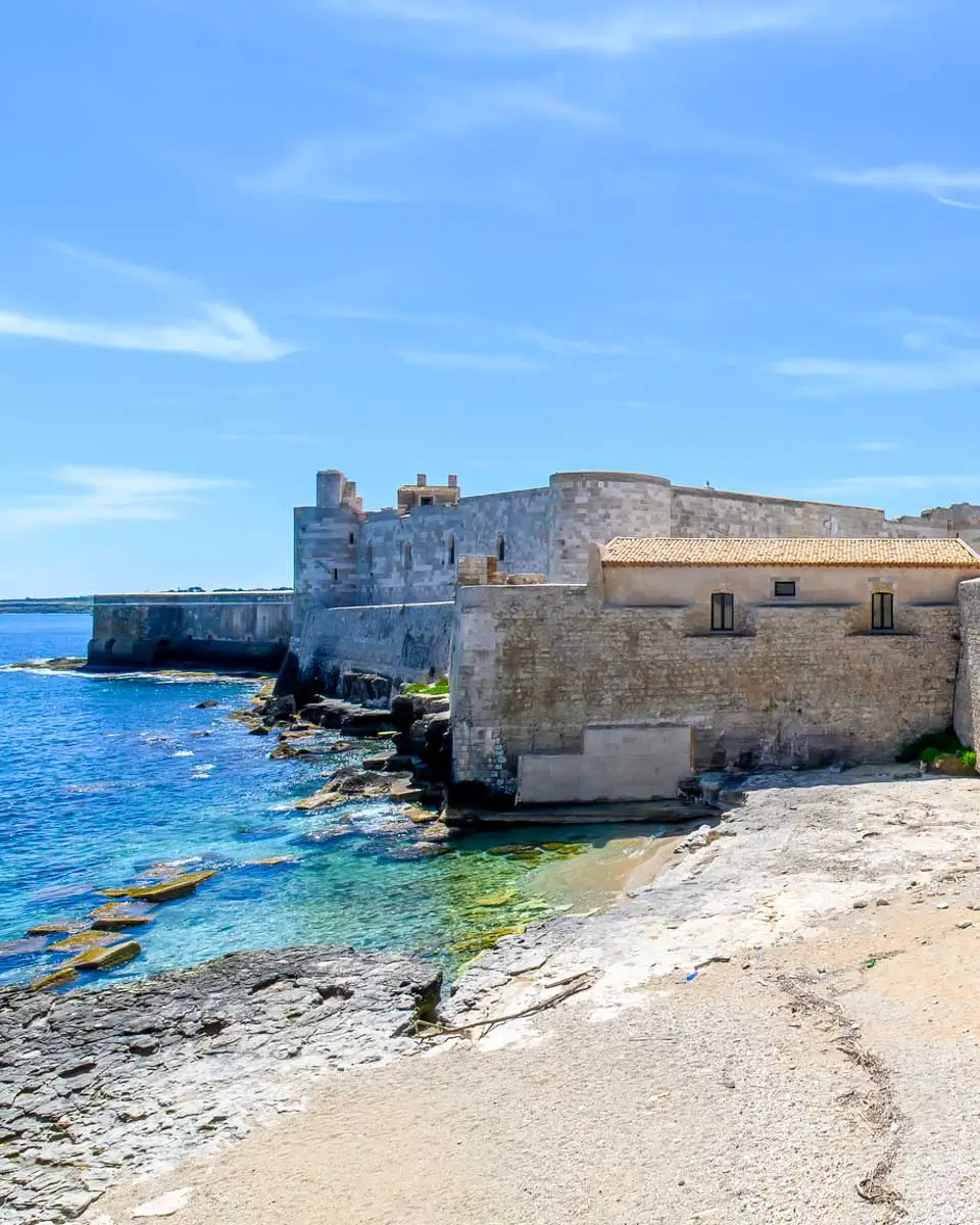 View of the historic Castello Maniace fortress and its stone bridge entrance on the tip of Ortygia island, Sicily, Italy