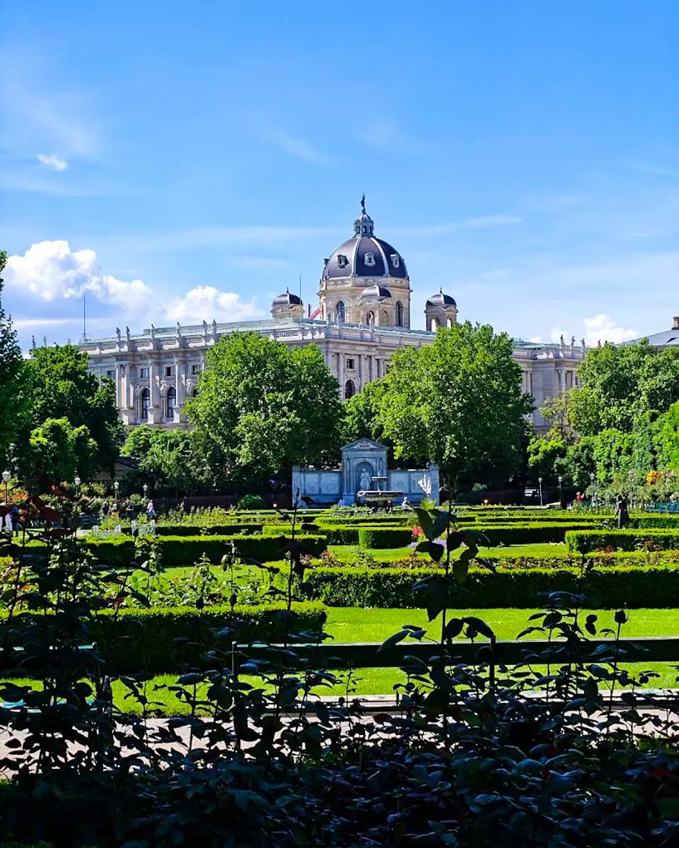 Landscaped gardens in Vienna's Volksgarten with the Kunsthistorisches Museum