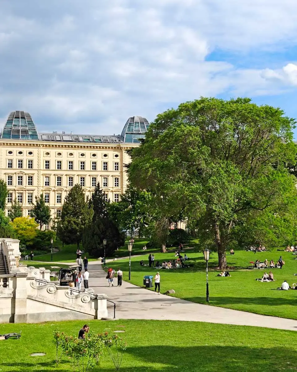 Visitors relaxing in the green lawns of Vienna's Volksgarten