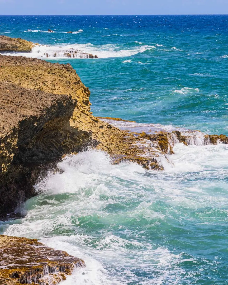 Waves crashing against rocky shore along Caribbean Sea coastline in Arikok National Park, Aruba