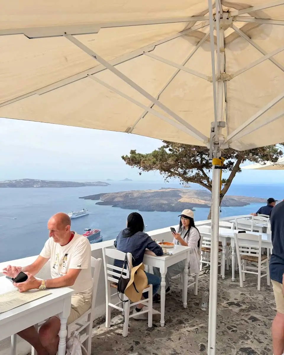 people eating at a restaurant in Santorini, Greece