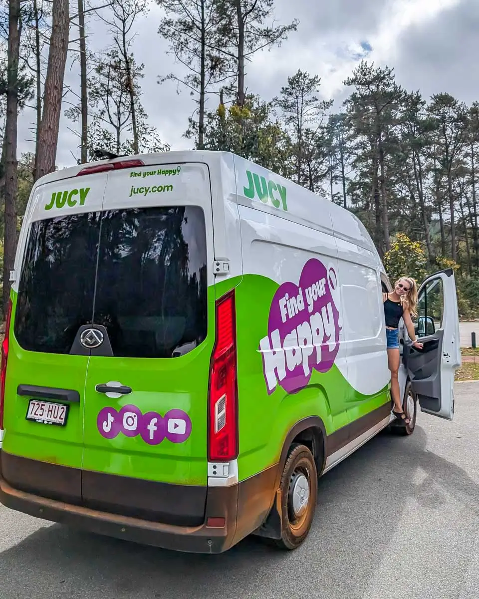 Bailey smiling and leaning out of JUCY campervan in Australia