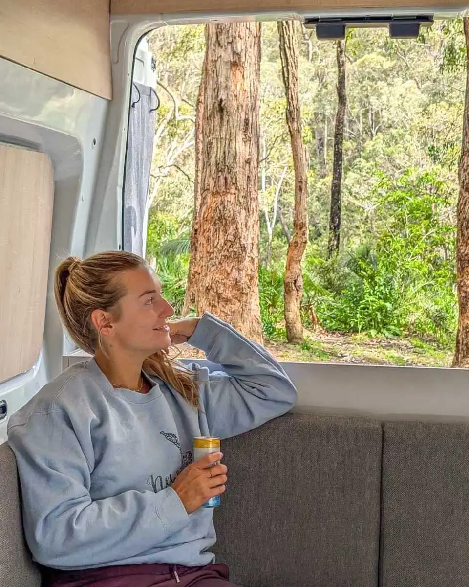 Bailey smiling and relaxing in the back of JUCY campervan in Australia