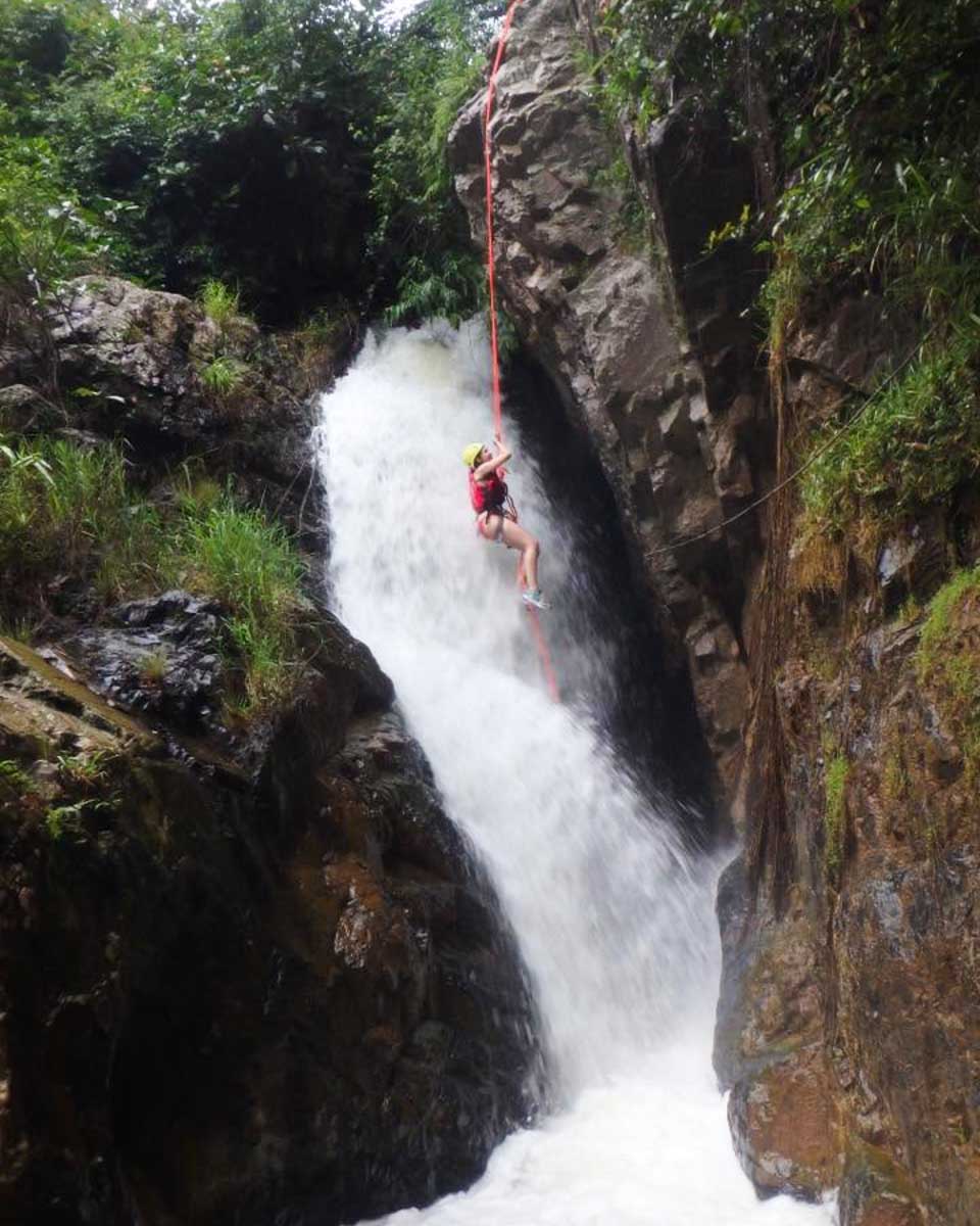 Brittni abseils down a waterfall on a tour in Dalat, Vietnam