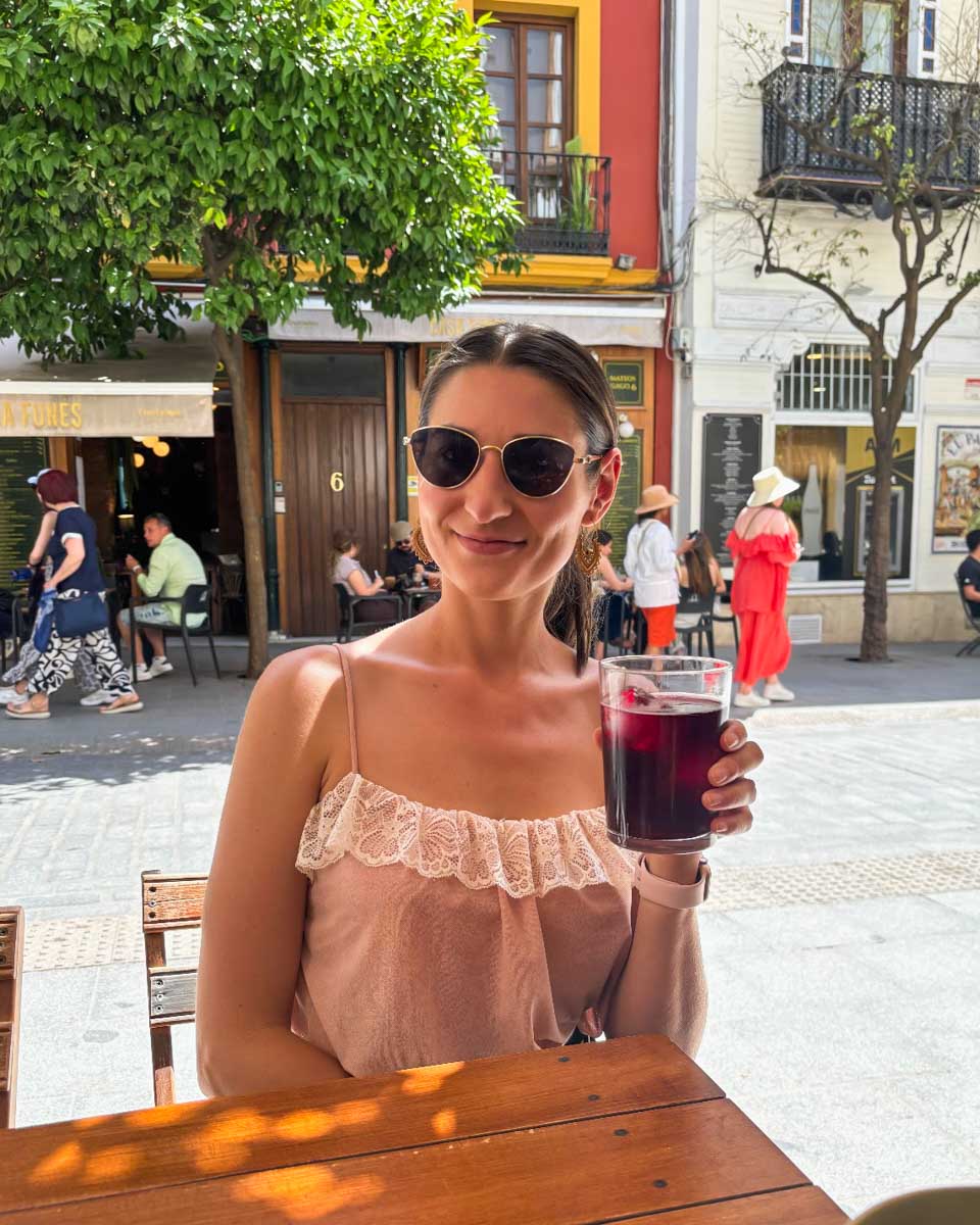 Brittni drinks sangria on a patio in Seville, Spain