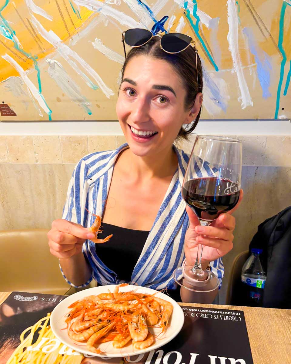 Brittni eats shrimp at a restaurant in Malaga, Spain