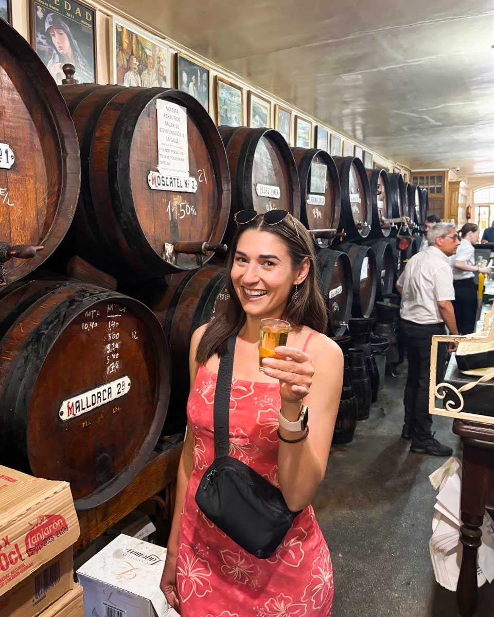 Brittni enjoys a sample of wine at a stop on a food tour in Malaga