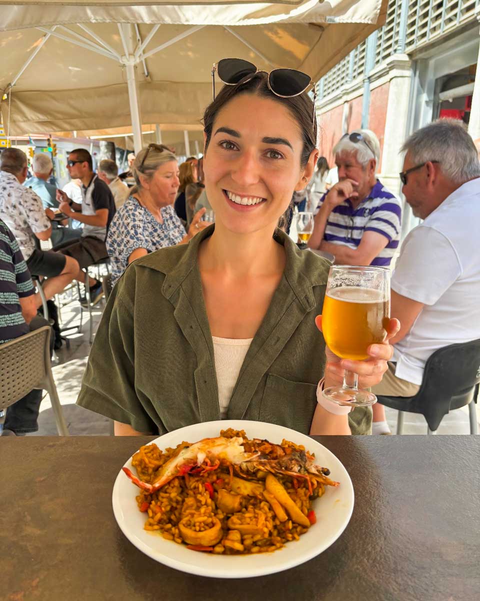Brittni enjoys seafood paella and a beer on the terrace at Mercado Central de Atarazanas in Malaga