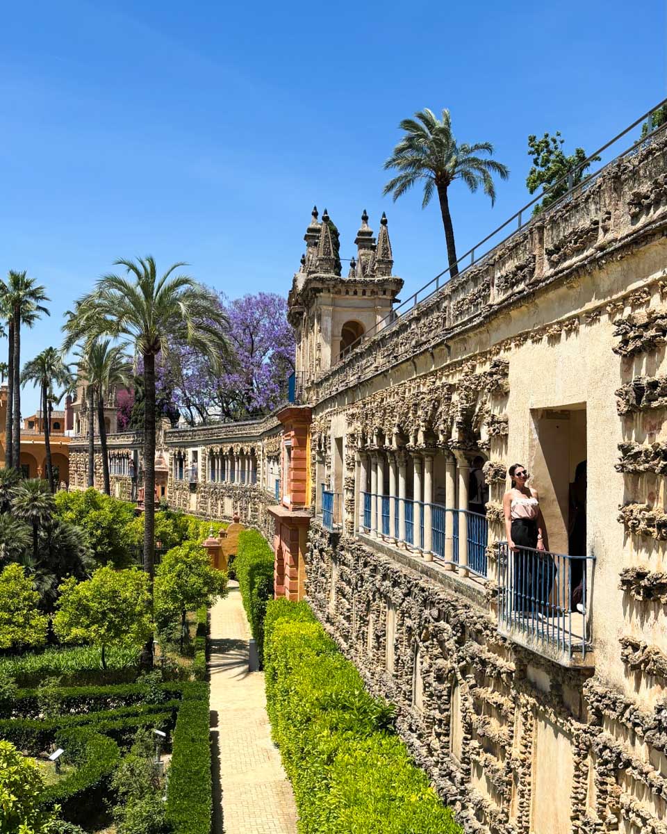Brittni stands in a doorway looking over the gardens of the Royal Alcazar of Seville