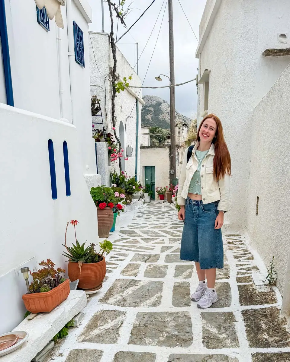 Hannah on the street between the whitewashed buildings of Naxos Greece