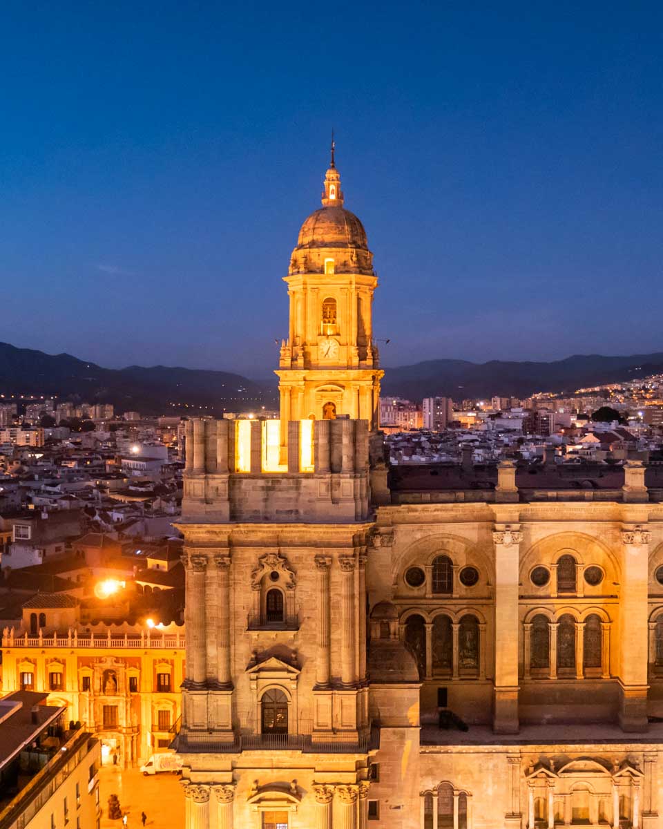 Malaga Cathedral illuminated at night seen from a rooftop bar