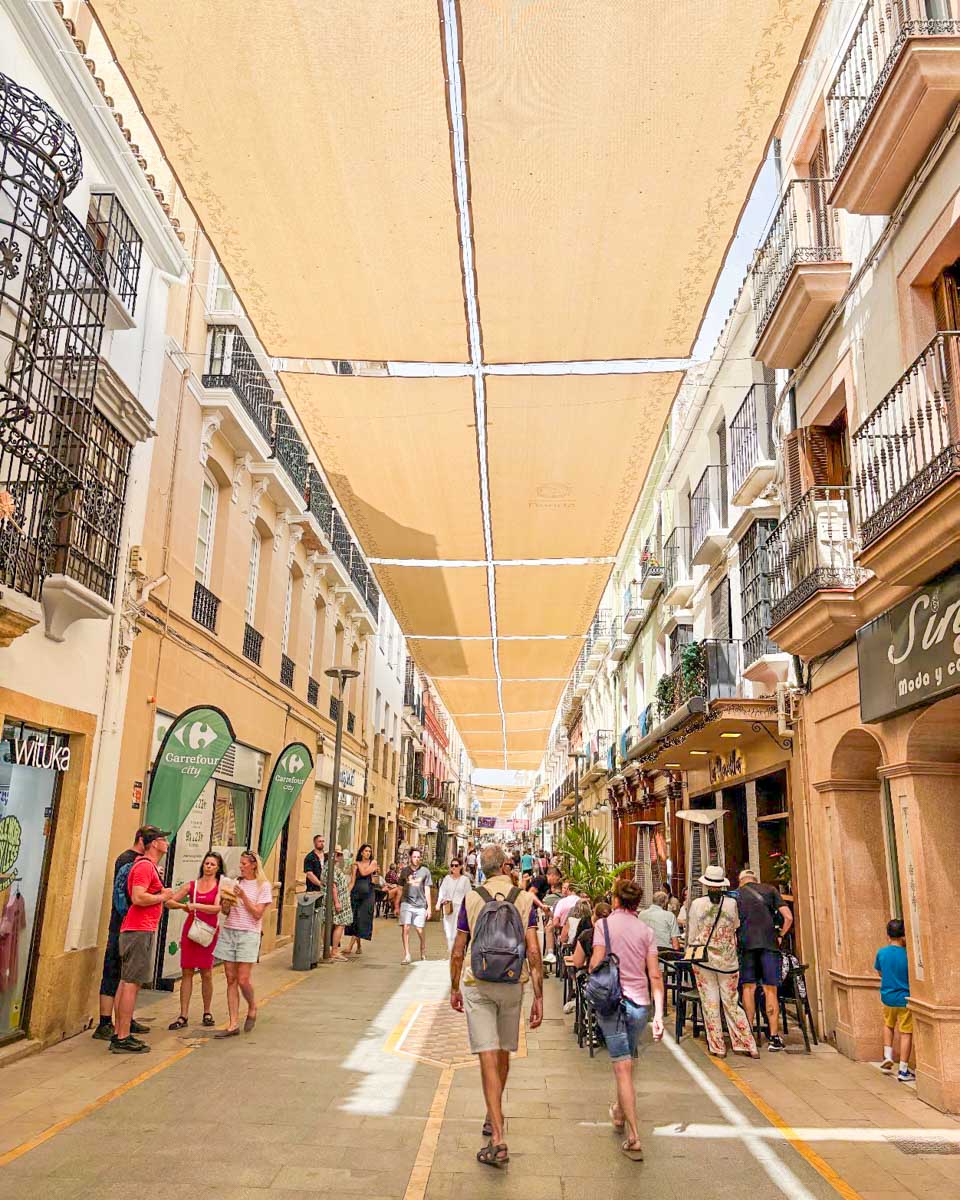 People walk along La Bola shopping street in Ronda, Spain