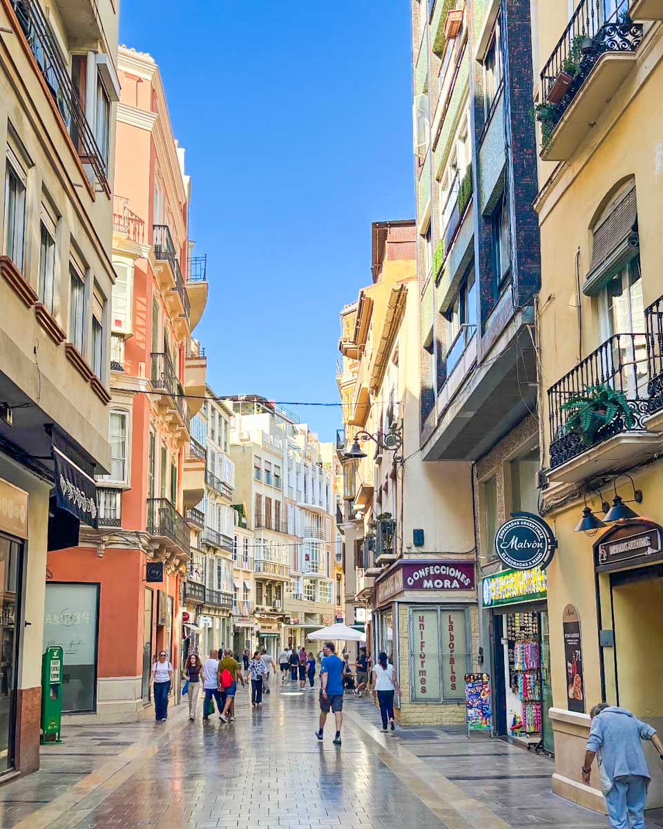 People walk along a street in central Malaga, Spain