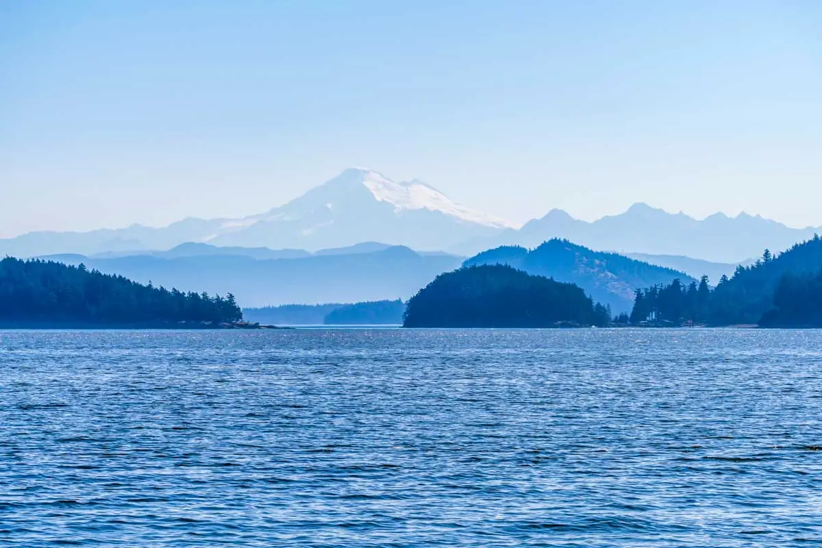 Telephoto view of Mt Baker in hazy distance through Obstruction Pass in San Juan Islands of Washington