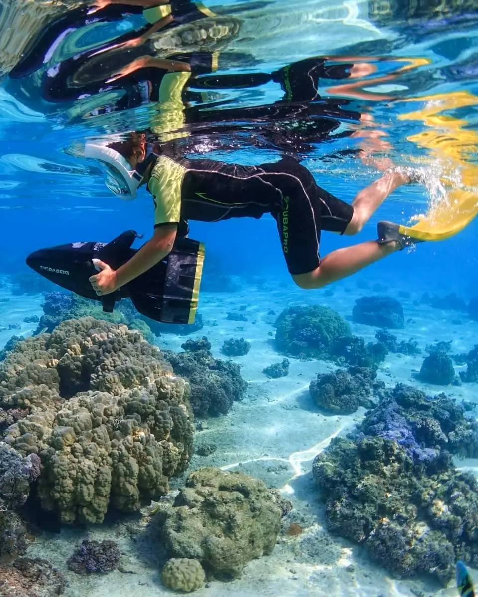 person under water riding a sea scooter in Moorea, French Polynesia