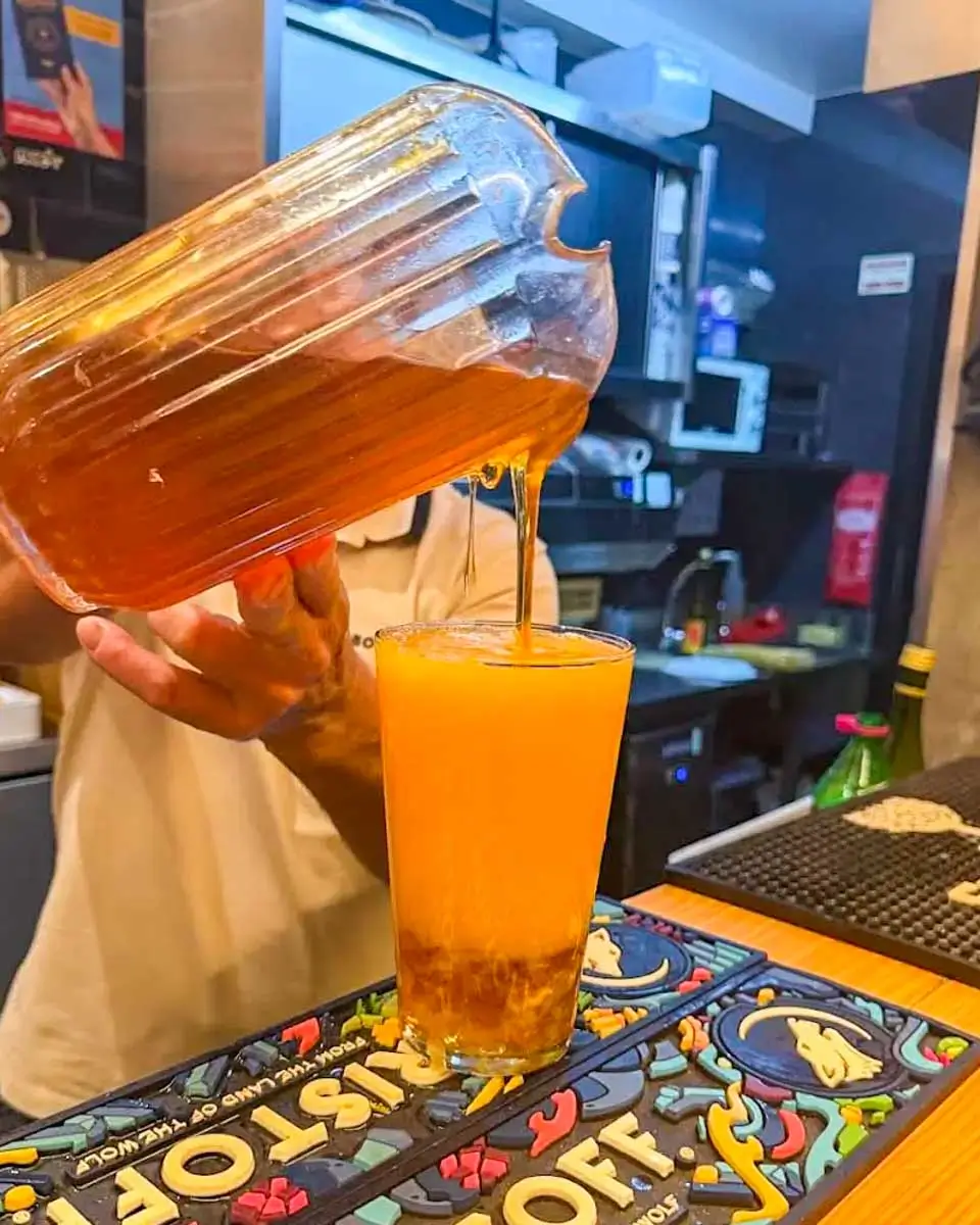 A man pouring poncha drink at a bar in Madeira Portugal