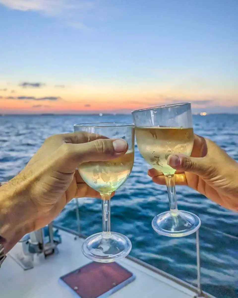 Bailey-and-Daniel-cheers-on-a-catamaran-at-sunset-in-Fort-Myers