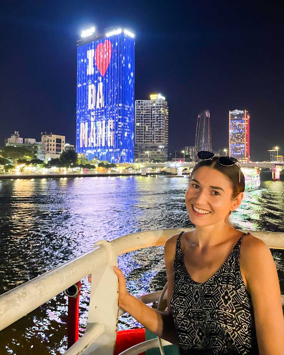 Brittni in front of a building that says I love Danang while on a Han River cruise in Vietnam