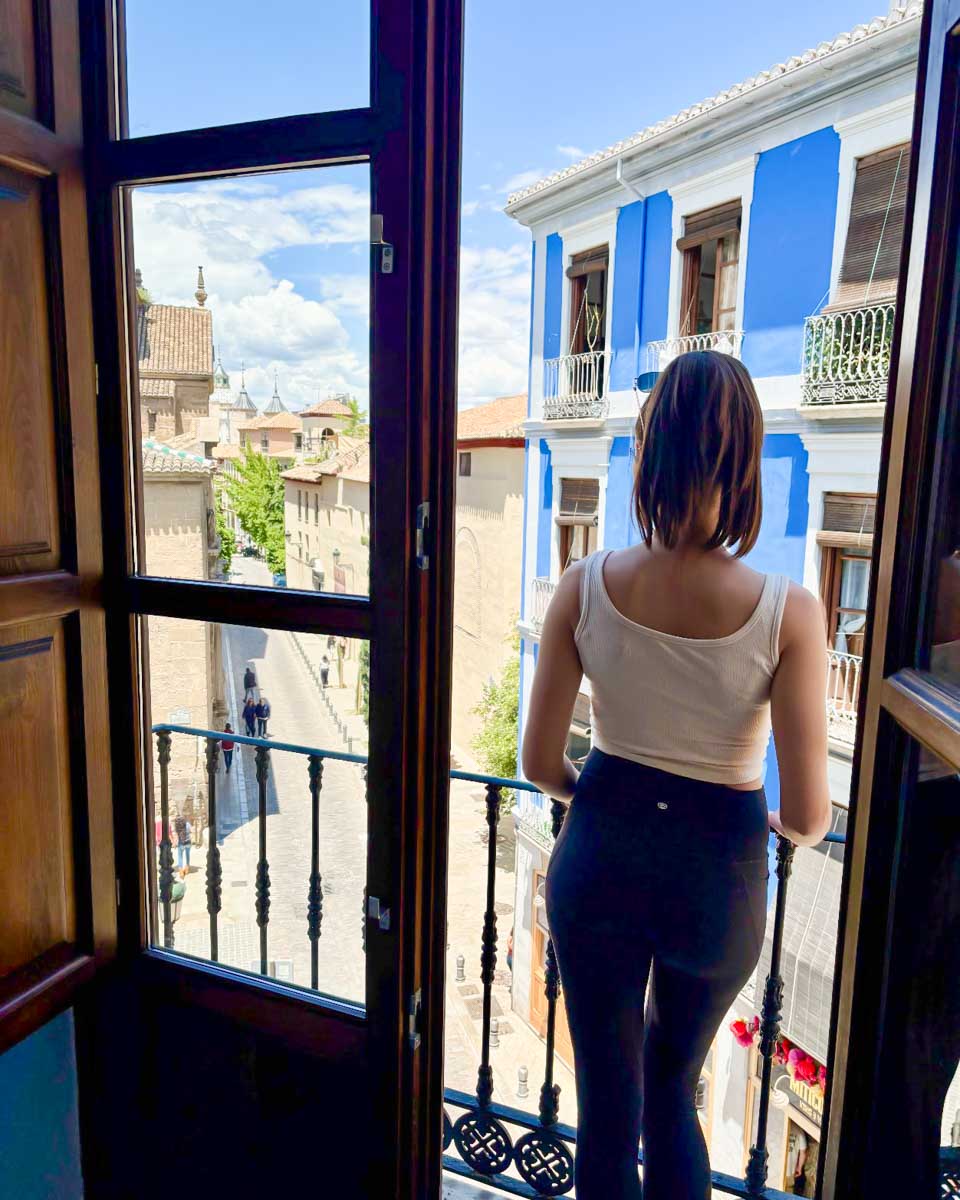 Brittni stands on the balcony of her room at La Perla Granada Suites