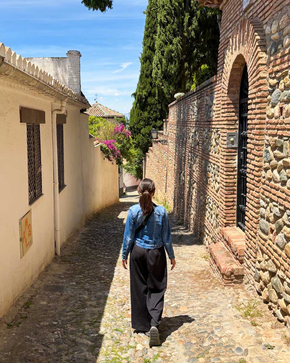 Brittni walks down a side street in Realejo, Granada