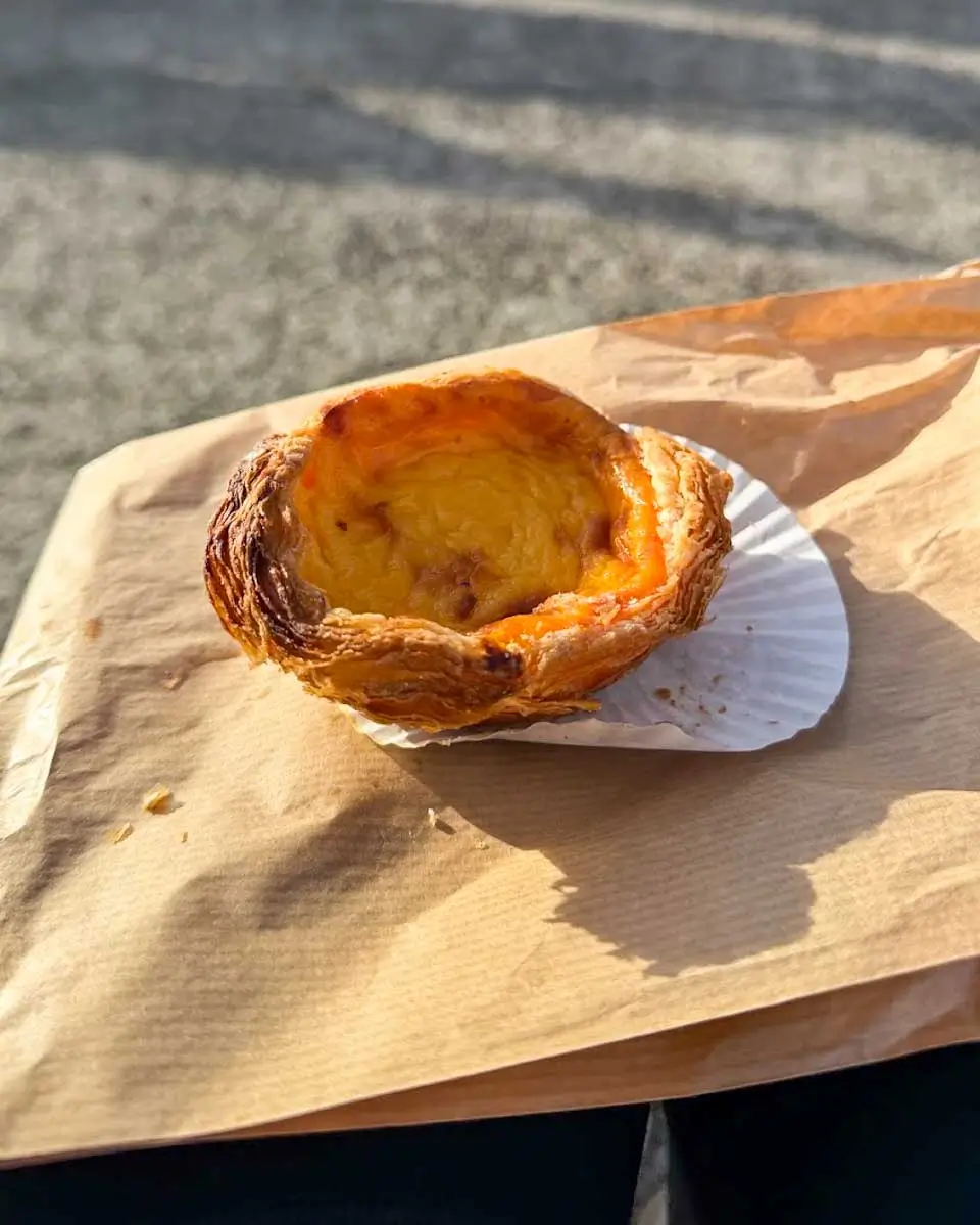 Hannah having Pastel de nata from Vera Cruz in Madeira, Portugal
