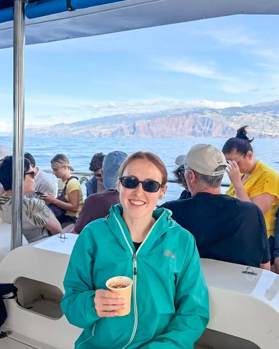 Hannah holding a drink on a dolphin and cruise tour in Madeira, Portugal