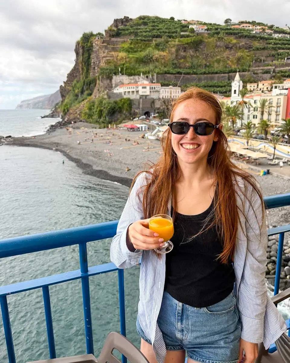 Hannah holding a glass of Poncha in Madeira, Portugal
