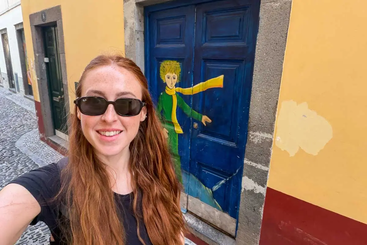 Hannah passing by a colorful door in Madeira, Portugal
