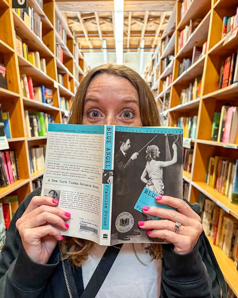 Meghan holding a book at Powell's Books store, Portland, Oregon